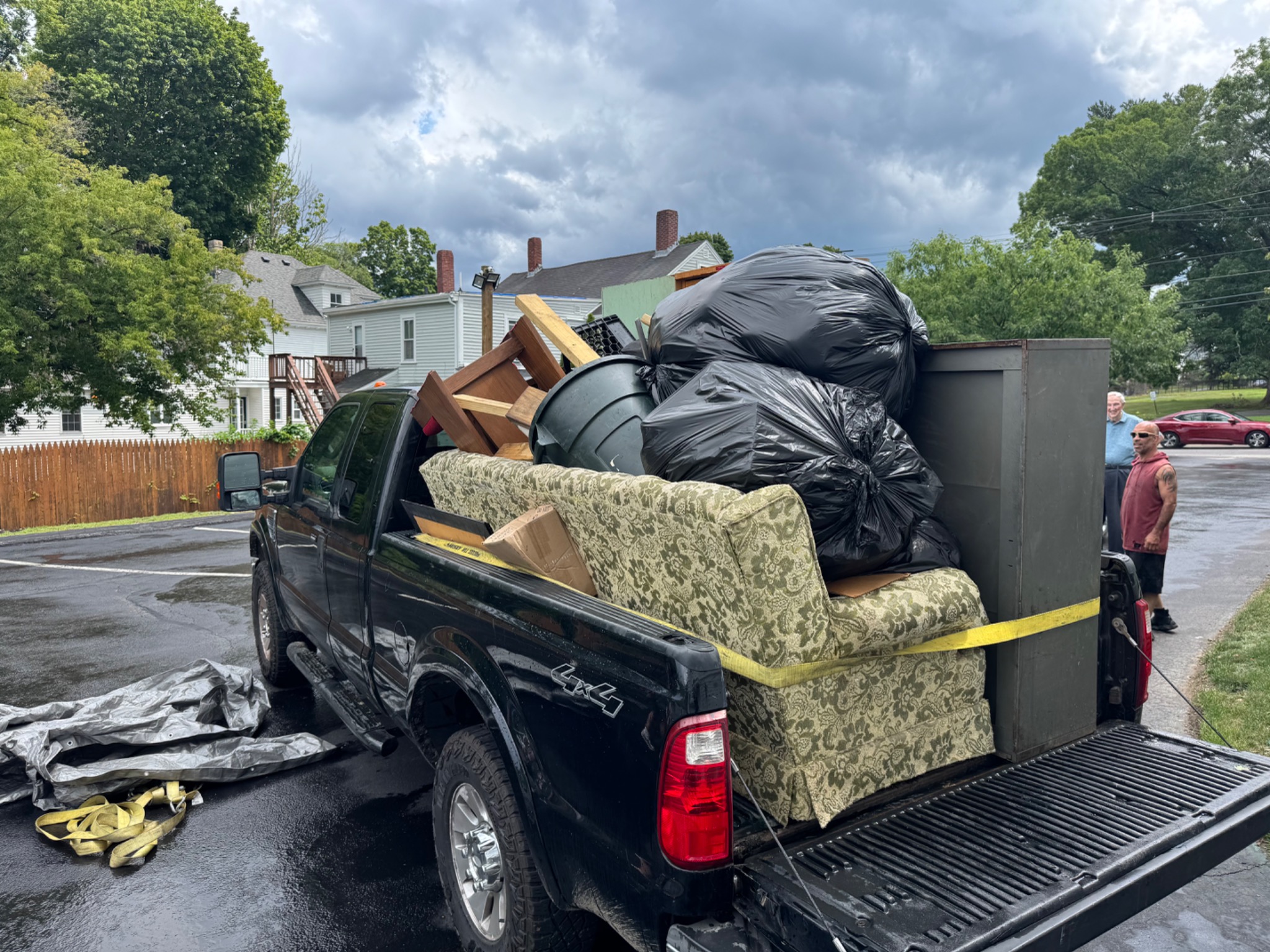 Pickup truck loaded with bagged household items and furniture for removal